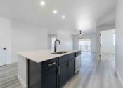 Thumbnail 22 of 49 - a white and black kitchen with a large counter top and a sink