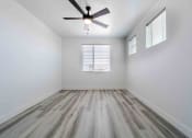 Thumbnail 25 of 49 - an empty room with wood floors and a ceiling fan
