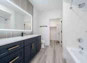 Thumbnail 24 of 49 - a bathroom with a large mirror and a sink and a toilet