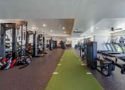 Thumbnail 9 of 49 - a spacious fitness center with cardio machines and weights