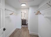 Thumbnail 42 of 63 - a closet in a bedroom with white walls and wood floors