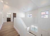 Thumbnail 31 of 63 - a view of a staircase in a home with white walls and wood floors
