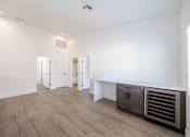 Thumbnail 34 of 63 - a living room with white walls and a wooden floor