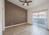 Thumbnail 33 of 63 - an empty living room with a ceiling fan and a sliding glass door