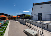 Thumbnail 57 of 63 - a rooftop patio with lounge chairs and umbrellas