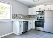 Thumbnail 2 of 30 - A kitchen with white cabinets and stainless steel appliances.