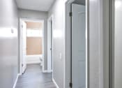 Thumbnail 11 of 30 - A hallway with a white door and a window.