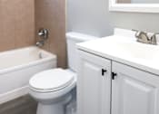 Thumbnail 14 of 30 - A white toilet sits next to a bathtub in a bathroom.