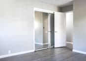 Thumbnail 12 of 30 - A room with a white door and a mirror on the wall.