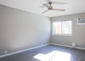 Thumbnail 19 of 30 - A room with a ceiling fan and a window.