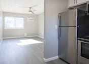 Thumbnail 20 of 30 - A kitchen with a stainless steel refrigerator and a ceiling fan.