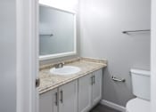 Thumbnail 22 of 30 - A bathroom with a sink, toilet and mirror.
