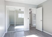 Thumbnail 23 of 30 - A room with a white door and a mirror on the wall.