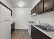 Thumbnail 2 of 18 - A kitchen with white appliances and brown cabinets.