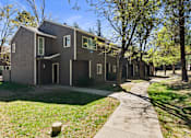 Thumbnail 17 of 18 - A modern house with a grey facade and a green lawn in front.