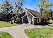 Thumbnail 16 of 18 - A building with a brown roof and a sign that says "OFFICE" is surrounded by trees and grass.