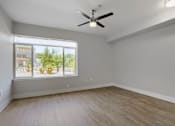 Thumbnail 19 of 32 - A room with a ceiling fan and a window showing a view of a storefront.