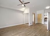 Thumbnail 18 of 32 - A room with a ceiling fan and wooden flooring.