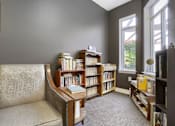 Thumbnail 30 of 32 - A room with a chair, a bookshelf, and a window.