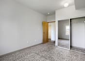 Thumbnail 21 of 32 - A room with a carpeted floor and a mirrored closet door.