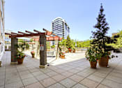 Thumbnail 3 of 32 - A patio with a red awning and potted plants.