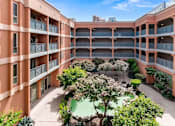 Thumbnail 1 of 12 - A courtyard with a tree and bushes surrounded by buildings at Pin Yuen, Sacramento