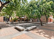 Thumbnail 4 of 12 - A courtyard with a fountain surrounded by trees and buildings at Pin Yuen