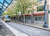 Thumbnail 6 of 32 - A yellow tram is on a street with a blue pole on the right.