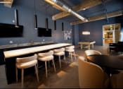 Thumbnail 1 of 28 - a bar with chairs and tables in a room with blue walls
