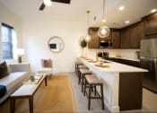 Thumbnail 5 of 28 - a kitchen and living room with a large island and a dining table
