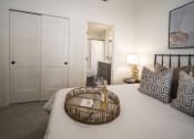 Thumbnail 13 of 28 - a bedroom with a white bed and a basket on top of it