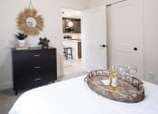Thumbnail 10 of 28 - a bedroom with a bed and a dresser with a mirror on the wall