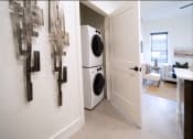 Thumbnail 11 of 28 - a laundry room with a washer and dryer and a door to a room