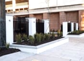 Thumbnail 21 of 28 - a courtyard with a fence and plants in front of a building