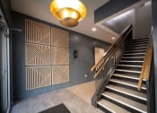 Thumbnail 24 of 28 - a staircase in a house with blue walls and a geometric wall art