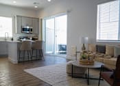 Thumbnail 23 of 31 - A modern kitchen with a dining area and a living room at Zora Encanto, Phoenix, AZ 85035