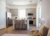 Thumbnail 26 of 31 - A modern kitchen with a dining area and a couch at Zora Encanto, Phoenix, Arizona