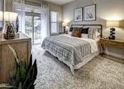 Thumbnail 28 of 40 - A bedroom with a bed, nightstands, and a ceiling fan at Arise Riverside Apartments, Austin, Texas