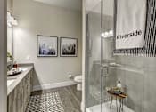 Thumbnail 36 of 40 - A bathroom with a glass shower stall and a towel hanging on the glass door at Arise Riverside Apartments, Austin, 78741