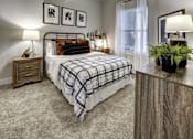 Thumbnail 31 of 40 - A bedroom with a bed, nightstands, and a plant. at Arise Riverside Apartments, Austin, TX, 78741