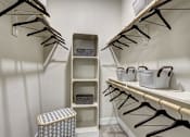 Thumbnail 35 of 40 - A white closet with a trash can and hangers at Arise Riverside Apartments, Austin, Texas