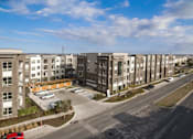 Thumbnail 39 of 40 - A row of apartment buildings with a parking lot in front at Arise Riverside Apartments, Austin, 78741