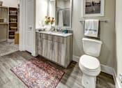 Thumbnail 37 of 40 - A bathroom with a rug on the floor and a toilet next to a sink at Arise Riverside Apartments, Austin, TX, 78741