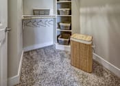 Thumbnail 33 of 40 - A white closet with a carpeted floor and a trash can at Arise Riverside Apartments, Austin, TX