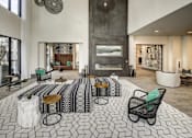 Thumbnail 4 of 40 - A black and white tiled floor with a patterned rug and a few chairs and tables at Arise Riverside Apartments, Texas 78741