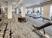 Thumbnail 19 of 40 - A gym with treadmills, weights, and exercise equipment at Arise Riverside Apartments, Austin, TX, 78741
