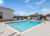 Thumbnail 6 of 31 - our resort style swimming pool is next to our building with umbrellas and chairs at Zora Encanto, Phoenix, AZ 85035