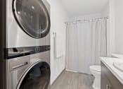 Thumbnail 5 of 25 - a washer and dryer in a bathroom with a shower and a toilet
