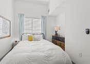 Thumbnail 8 of 25 - a bedroom with a white bed and a window