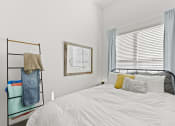 Thumbnail 12 of 25 - a white bedroom with a bed and a window